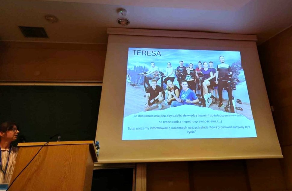 osoba przy ekranie, na którym wyświetlana jest prezentacja 